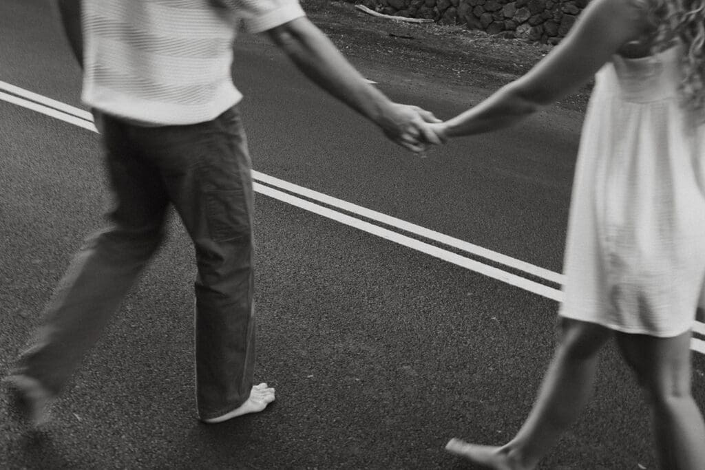 Couple Holding Hands On A Road On The Big Island At Sunset